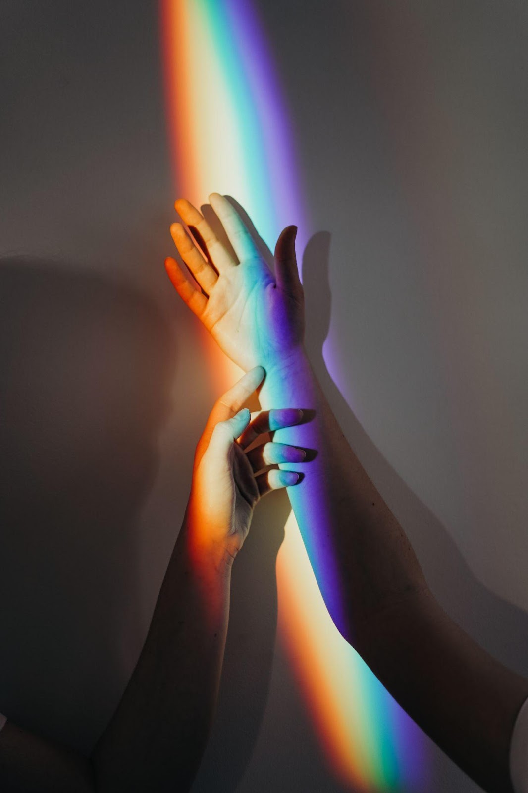 Hands with a rainbow over them
